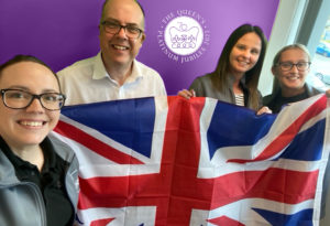 Gamma Sales team waving a Union Jack to celebrate the Queen's Platinum Jubilee